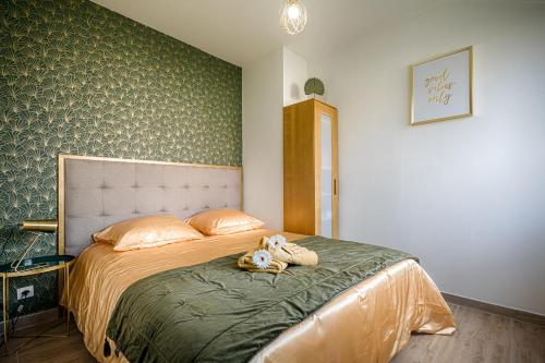 um quarto com uma cama com um bicho de peluche em Appartement hyper centre, charme & confort em Valenciennes