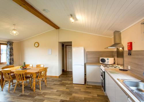 a kitchen and dining room with a table and a refrigerator at High Lodge in Darsham