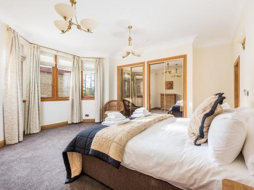a bedroom with two beds and a large window at Piperdam House in Lundie