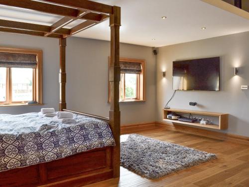 a bedroom with a bed and a tv and a rug at Carr End Barn A in Preesall
