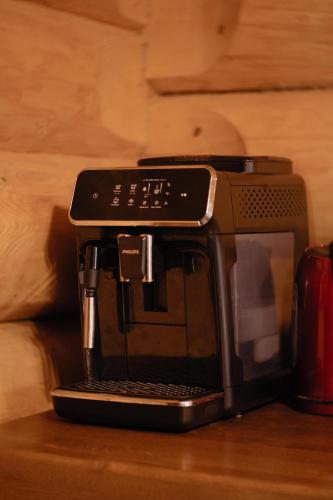 a black coffee maker sitting on top of a table at Viesu nams “Kalna Raskumi” in Vecpiebalga
