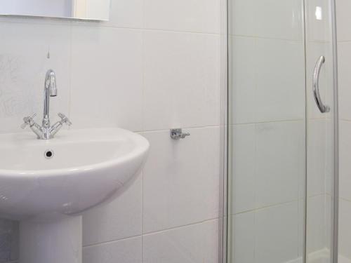 een witte badkamer met een wastafel en een douche bij Sunnyside in Filey
