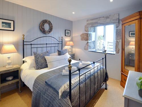 a bedroom with a large bed and a window at The Stable in Crowan