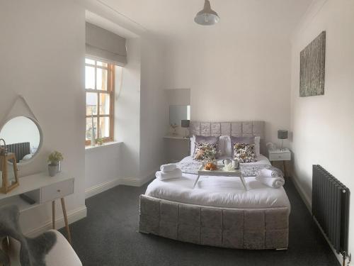 a bedroom with a large bed and a mirror at Seafield Street in Cullen