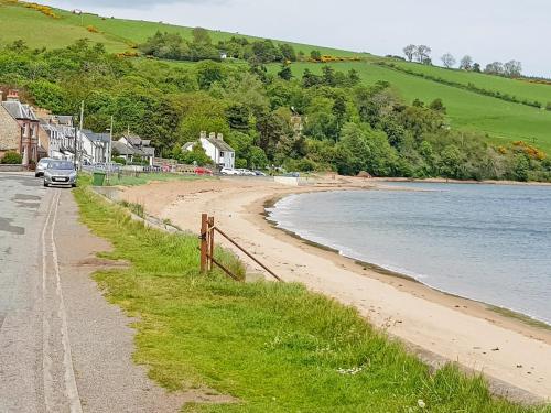 a car parked on a road next to a beach at The Pine Martin - Uk31005 in Avoch