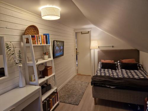 a bedroom with a bed and a book shelf at Eldaren in Tranås