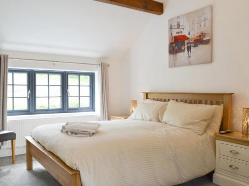 1 dormitorio con 1 cama blanca grande y ventana en Woodhouse View, en Helsby