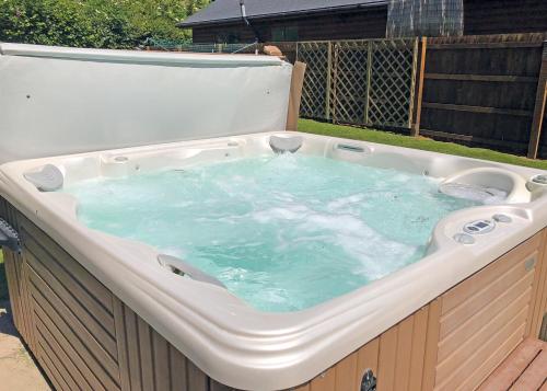 a large hot tub sitting in a backyard at Heartsease Lodges in Llanddewi Ystradenny