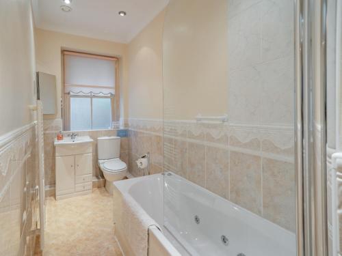 a bathroom with a tub and a toilet and a sink at Mell Fell in Watermillock