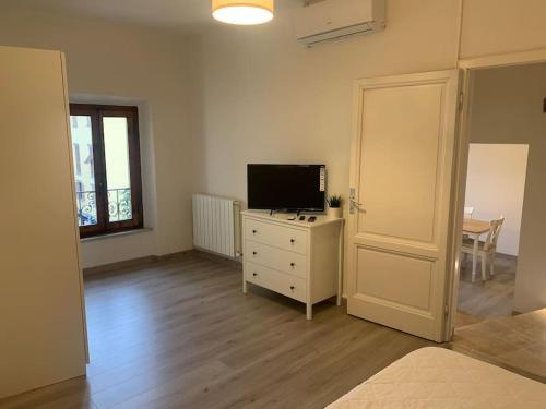 a living room with a television on a dresser and a table at La casa di Tommy in Monsummano