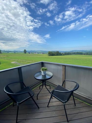 a patio with two chairs and a table on a balcony at Kanylosek Luksusowe Domki Drewniane in Czerwienne