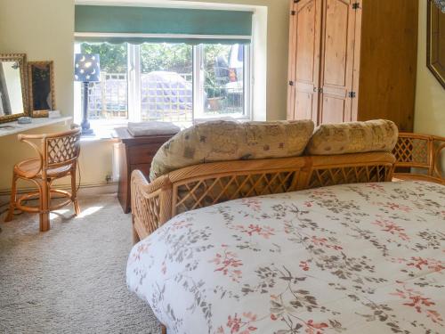 a bedroom with a bed and a chair and a window at Ty Sally Jones in Bwlch