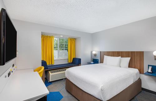 a hotel room with a bed and a tv at Microtel Inn & Suites Columbus North in Columbus