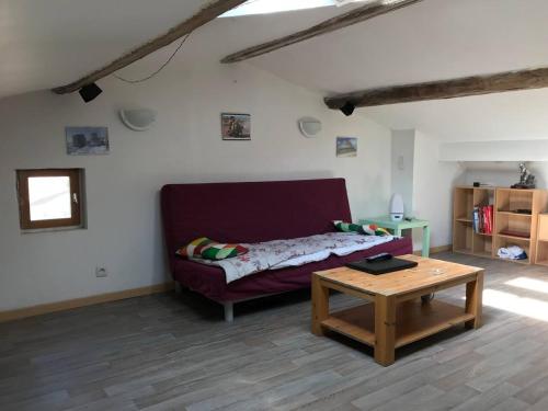 - un salon avec un canapé violet et une table basse dans l'établissement Appartement en Provence avec possibilite garage motos et velo, à Salernes