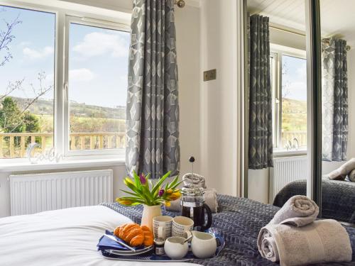 a tray of food on a bed in a room with a window at The View - Uk36812 in Whalley