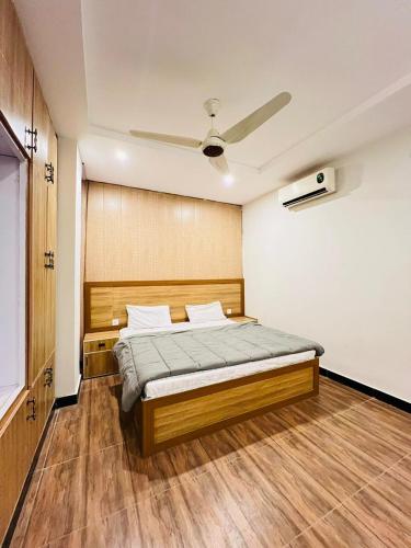 Schlafzimmer mit einem Bett und einem Deckenventilator in der Unterkunft Noors B&B in Islamabad