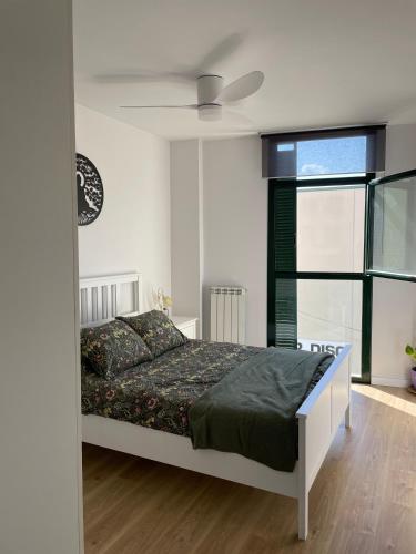 a bedroom with a bed and a ceiling fan at Acogedor apartamento Vallparadís con parking in Terrassa