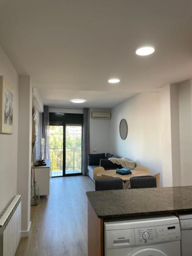 Acogedor apartamento Vallparadís con parking في تيراسا: غرفة مع غرفة معيشة مع أريكة وغرفة معيشة