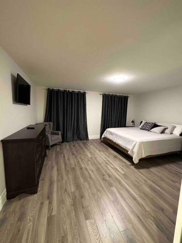 a bedroom with a large bed and a wooden floor at Stylish House W a Media Room Near Downtown Picton in Picton