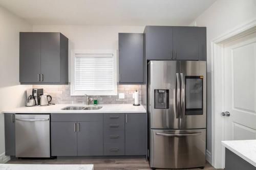 a kitchen with a stainless steel refrigerator and a sink at Stylish House W a Media Room Near Downtown Picton in Picton