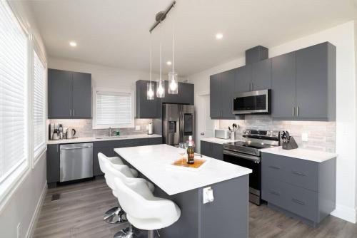 a kitchen with black cabinets and a white counter top at Stylish House W a Media Room Near Downtown Picton in Picton