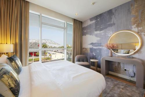 - une chambre avec un grand lit blanc et un miroir dans l'établissement WORLD CLASS 3BR in the HEART of DUBAI, à Dubaï