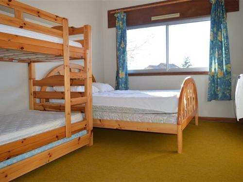 une chambre avec deux lits superposés et une fenêtre dans l'établissement Appartement cosy 2 pièces, terrasse ensoleillée, skis aux pieds, animaux acceptés, Bolquère - FR-1-592-59, à Bolquère-Pyrénées 2000