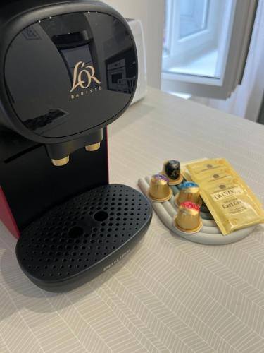 a coffee maker on a table with a plate of food at « Le Michelet »un cocon en ville in Saint-Étienne