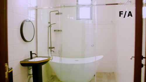 a bathroom with a tub and a sink and a shower at Favourite Luxury 3 Bedroom Apartment in Ikeja