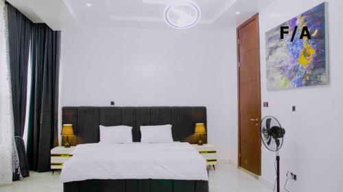 a bedroom with a large bed with white sheets at Favourite Luxury 3 Bedroom Apartment in Ikeja