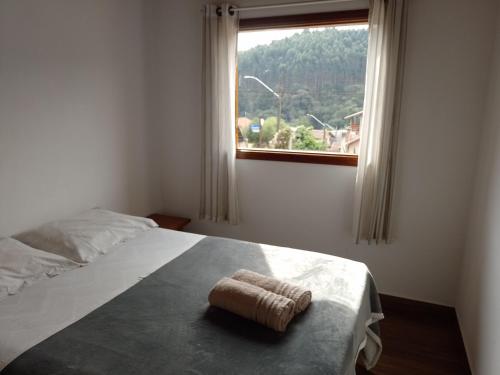 a bedroom with a bed with a towel on it at Chalé refúgio in Monte Verde