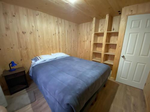 a bedroom with a bed in a room with wooden walls at Cabañas Austral Rivers in Puelo