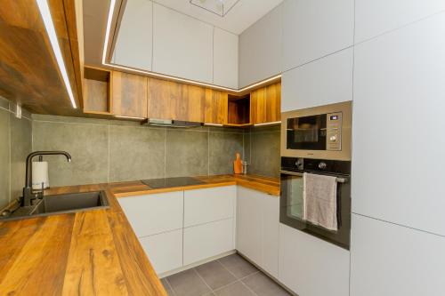 a kitchen with white cabinets and a sink at MT SUITES BUDAPEST in Budapest