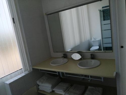 een badkamer met 2 wastafels en een grote spiegel bij T2 Maralvor in Alvor
