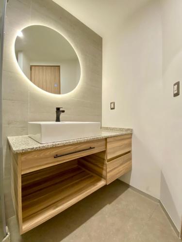 a bathroom with a sink and a mirror at Second Home Darwin in Mexico City