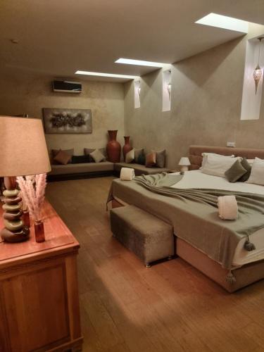 a bedroom with a large bed and a couch at Les terrasses du Lac Marrakech in Lalla Takerkoust
