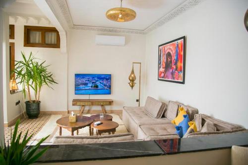uma sala de estar com um sofá e uma mesa em Riad Sabria em Marrakech