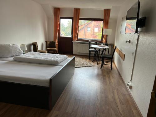 Schlafzimmer mit einem Bett, einem Tisch und Stühlen in der Unterkunft Piets Gästezimmer in Sandstedt