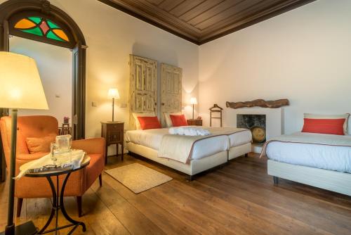 a bedroom with two beds and a couch and a table at Casa De Campo Colmeal in Mira