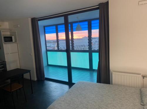 a bedroom with a view of a balcony at Studios de standing - Emeraude - Lille euralille in Lille