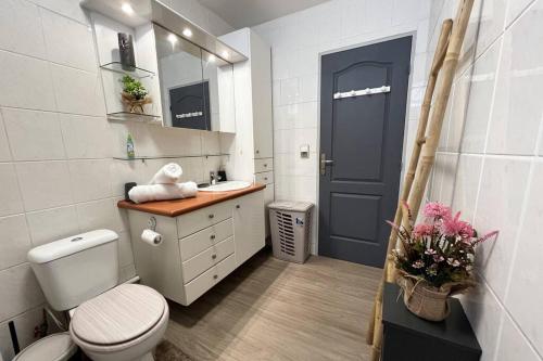 uma casa de banho com um WC, um lavatório e uma porta azul em HEIPOE LODGE - 6 min airport, Wifi, AC & Parking em Papeete