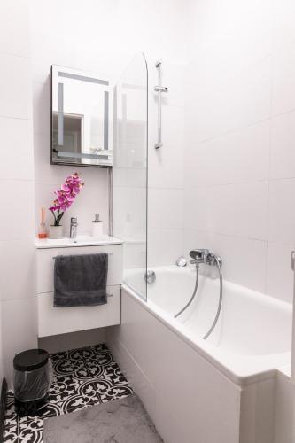 a bathroom with a tub and a sink and a mirror at ClickTheFlat Krucza City Center Apart Rooms in Warsaw