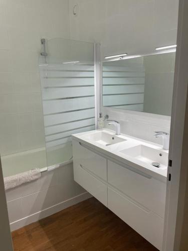 une salle de bain blanche avec un lavabo et un miroir dans l'établissement Le 7ème Ciel - 3 étoiles, à Thonon-les-Bains