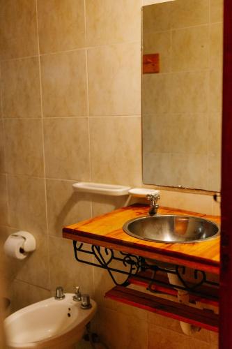 a bathroom with a sink and a mirror and a toilet at Confratelli Cabañas in Paso de la Patria
