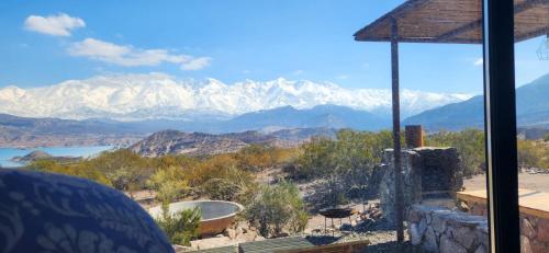 a view of snow covered mountains from a house at La Calma Ecolodge in Las Heras