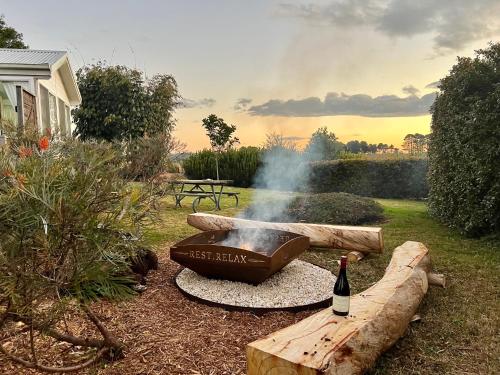 a bottle of wine sitting next to a grill with a bottle of wine at Orange Blossom- Comboyne Mountain Cottages in Comboyne