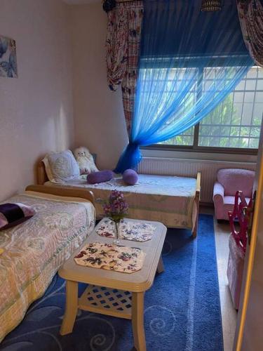 Zimmer mit 2 Betten und einem Tisch in der Unterkunft 3 bedroom apartment in Ţāb Kirā‘