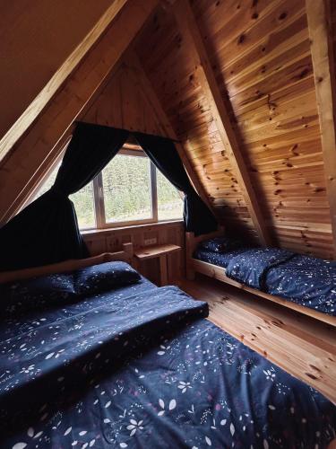 a bedroom with two beds in a attic at Nomad Lodge Zminica in Žabljak