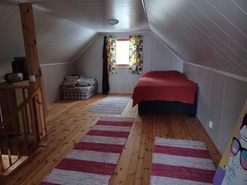 Habitación en el ático con cama roja y ventana en Jamali Cabin, en Lieksa