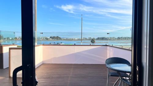 a balcony with two chairs and a view of the ocean at Marineland Beachfront Accommodation in Napier